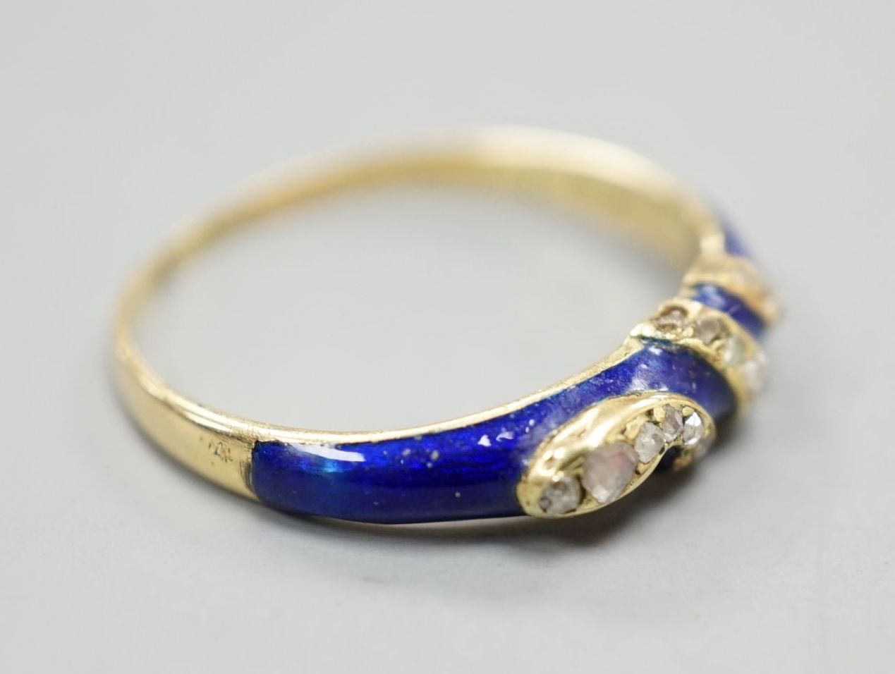 A late Victorian yellow metal, blue enamel and rose cut diamond set serpent ring, size O, gross weight 2.5 grams.